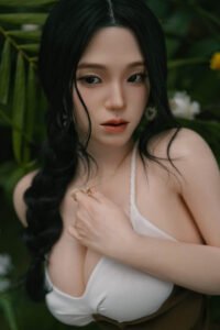 Close-up portrait of a woman with long black hair and red lips among green plants.